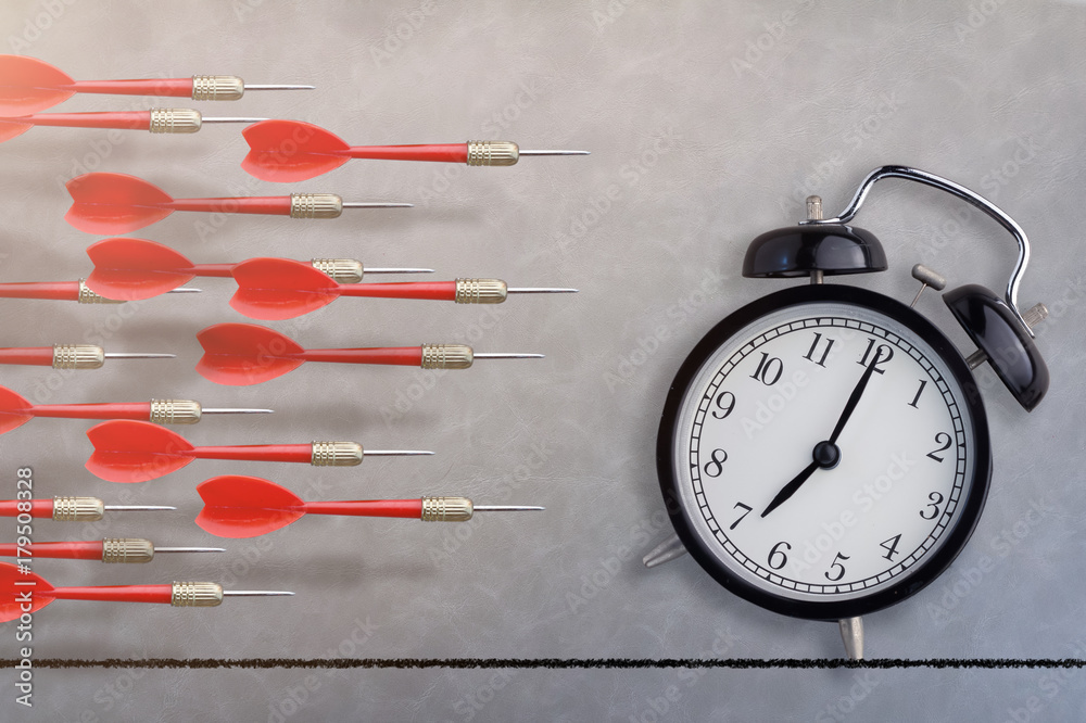 black alarm clock and red dart arrow fly on  gray leather texture floor background free copyspace fo