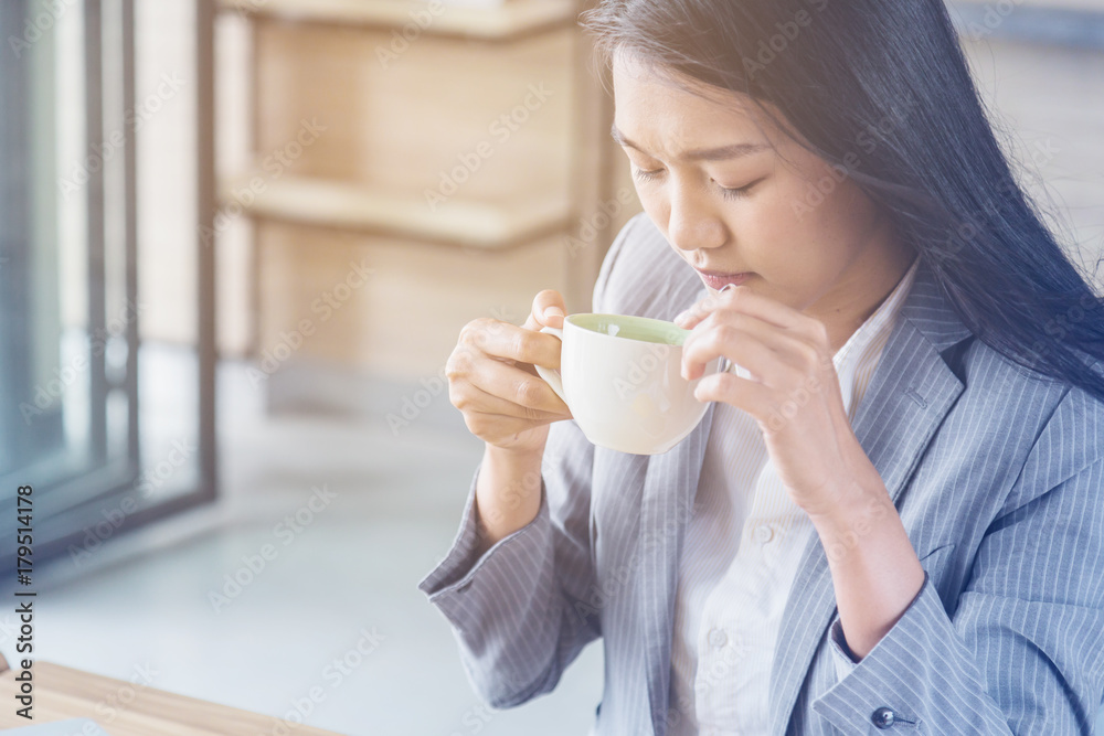 asian tan skin business woman drink hot coffee in the morning workday