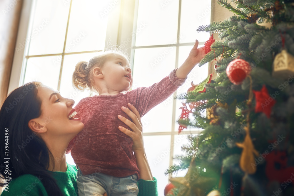 Mom and daughter decorate Christmas tree