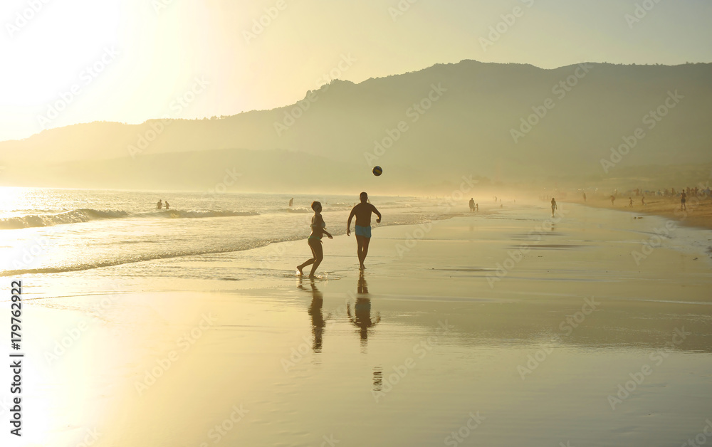 Pareja jugando con un balón en la playa de Bolonia, costa de Cádiz, España