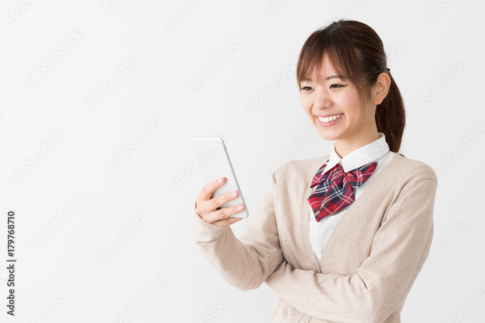 スマートフォンを使う女子高生