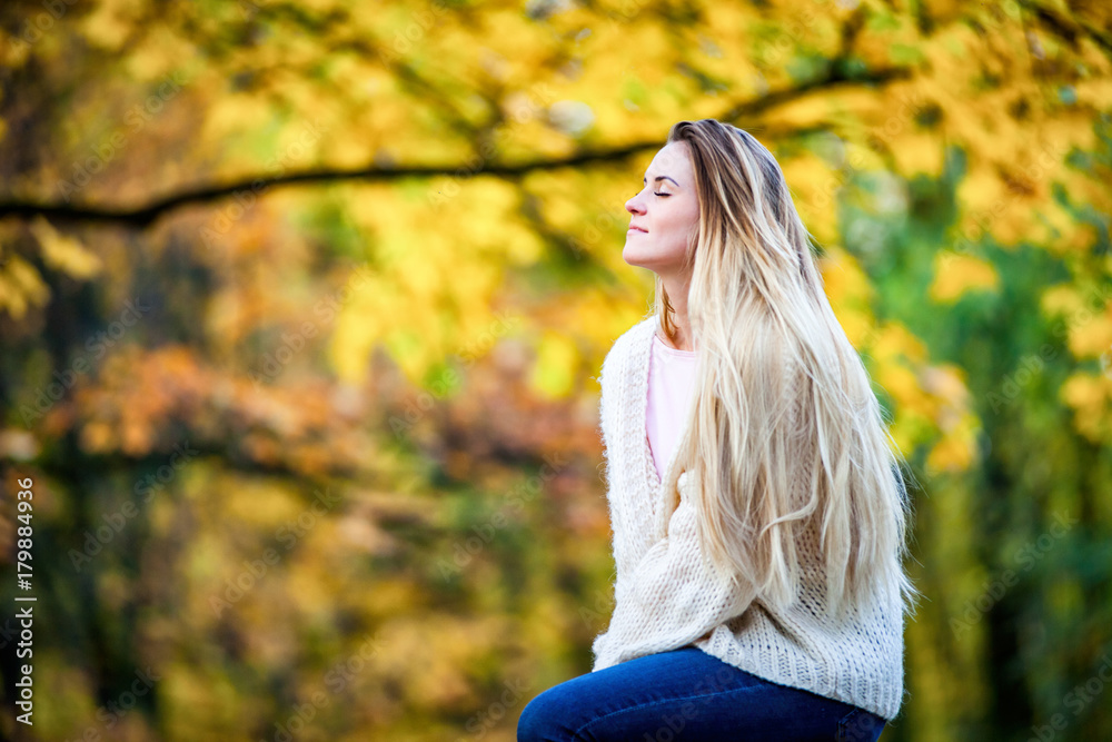 Beautiful young girl in the colorful autumn park