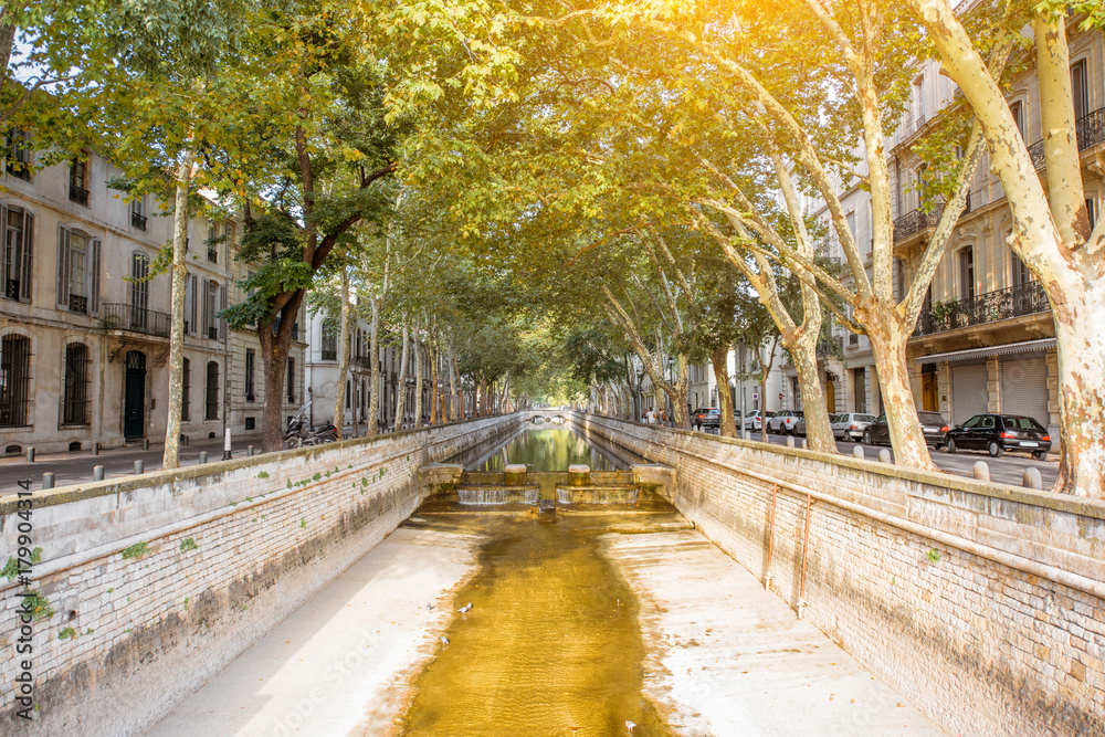 View on the beautiful water channel during the sunny day in Nimes city in the Occitanie region of so