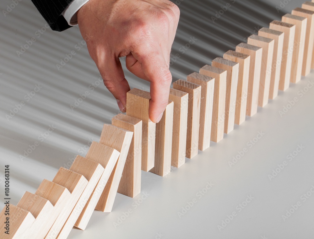 Closeup of Businessman Hand Grabbing Domino Piece