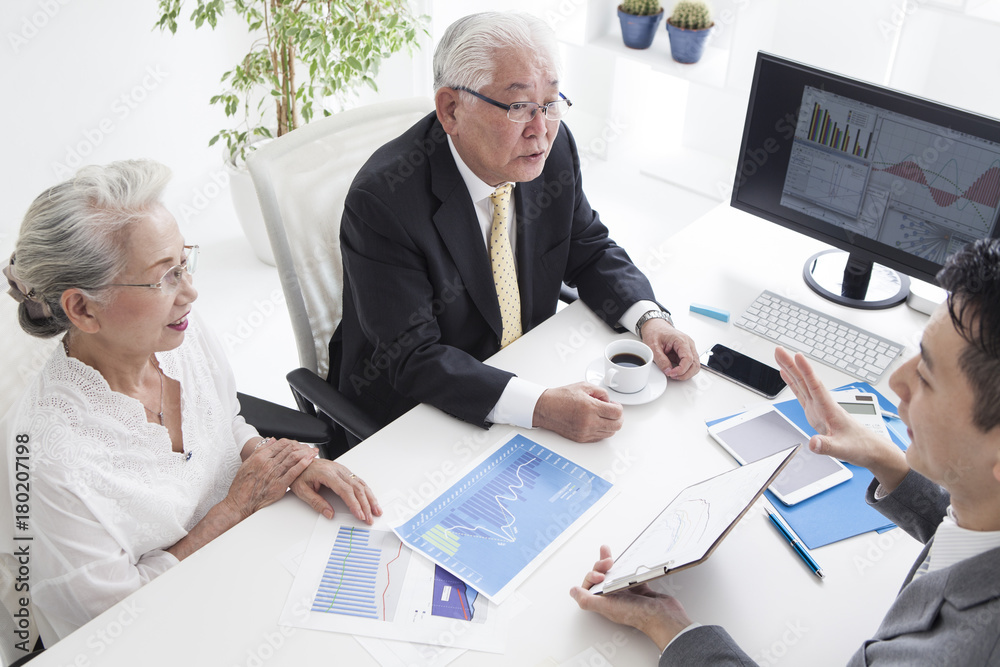 Sales person and old couple are simulating mortgage