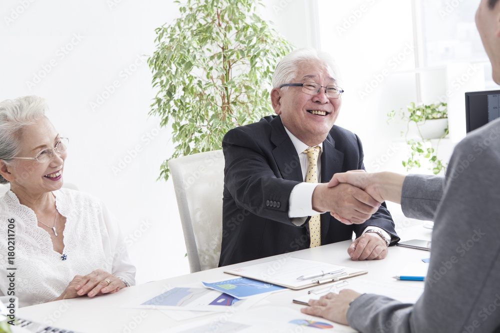 An old man shaking hands with a salesperson