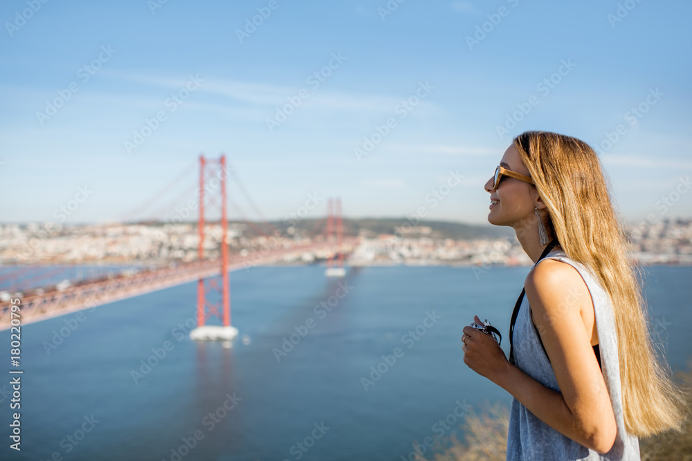 年轻的女游客在里斯本著名的铁桥上欣赏美丽的空中景观