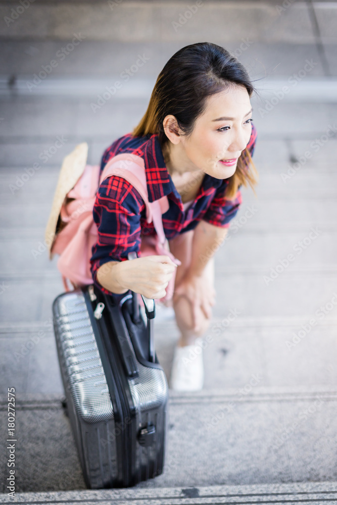 亚洲美女背着背包和行李箱旅行，城市背景旅行旅游创意c