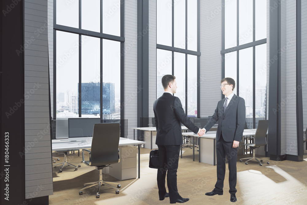 Businessmen shaking hands in office