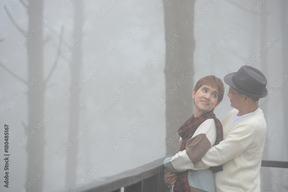 Portrait of happy romantic senior couple outdoor at the sea of fog