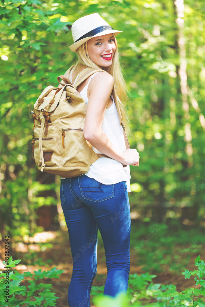 Young woman walking on a forest trail on a beautiful summer day