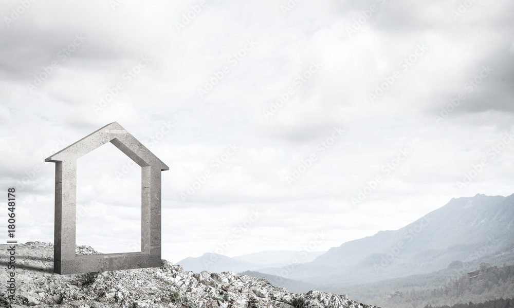 Conceptual image of concrete home sign on hill and natural lands