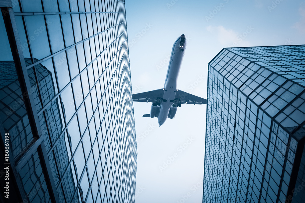 airplane above modern building