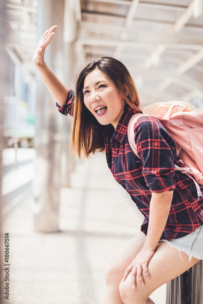 亚洲美女背着背包和行李箱旅行，城市背景旅行旅游创意c