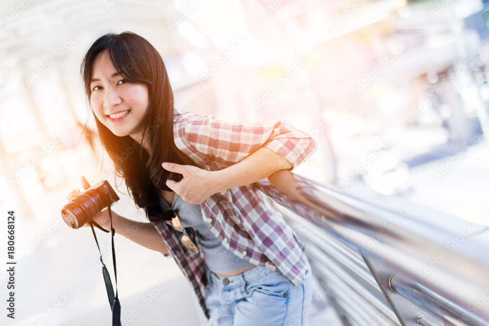 美丽幸福的年轻亚洲女孩穿着休闲服独自在火车站或机场旅行