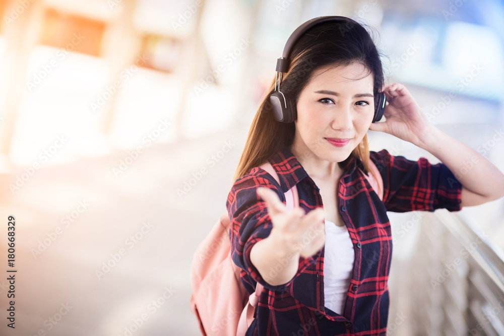 美丽幸福的年轻亚洲女孩穿着休闲服独自在火车站或机场旅行