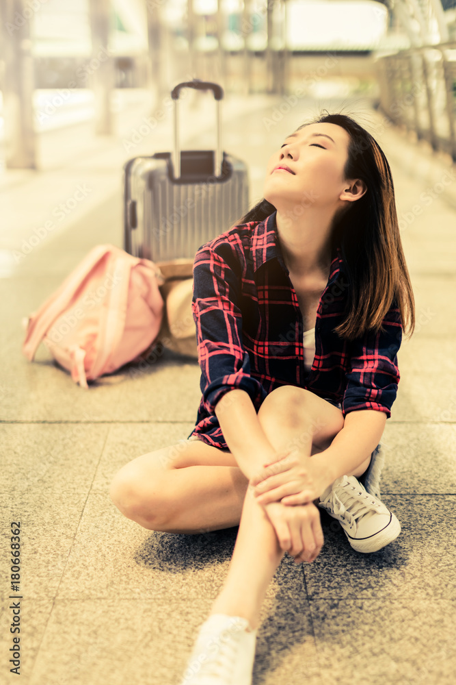 美丽幸福的年轻亚洲女孩穿着休闲服独自在火车站或机场旅行