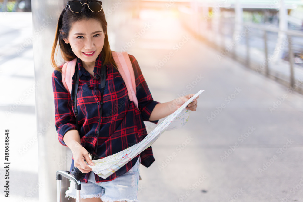 美丽幸福的年轻亚洲女孩穿着休闲服独自在火车站或机场旅行