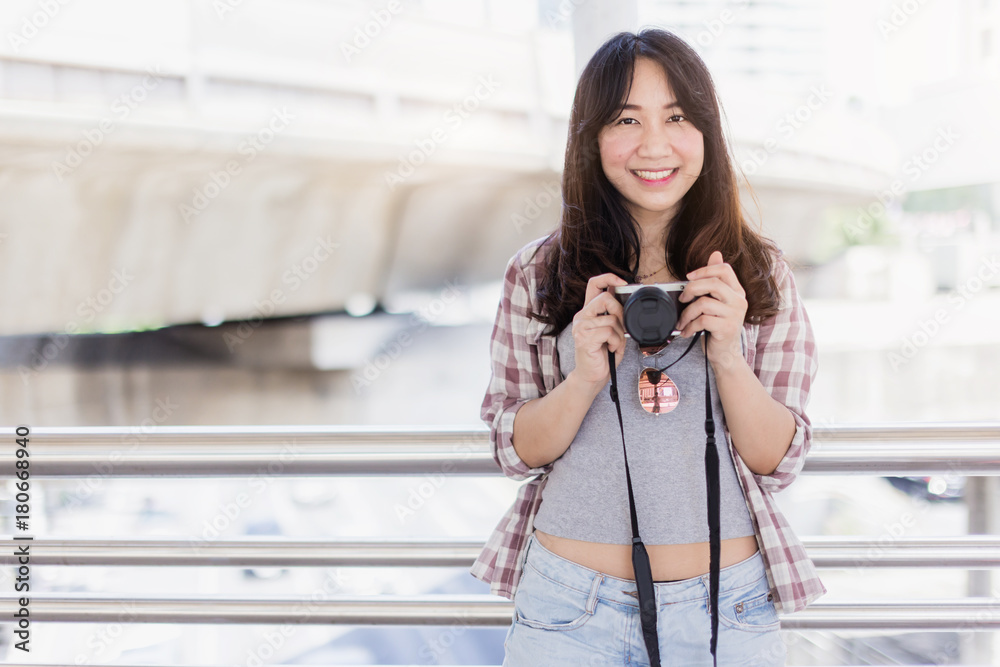 美丽幸福的年轻亚洲女孩穿着休闲服独自在火车站或机场旅行