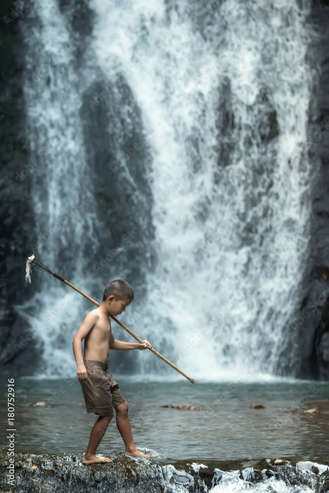 Asian boys fishing in the river at countryside Thailand.