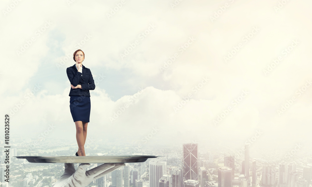 Confident elegant businesswoman presented on metal tray against cityscape background