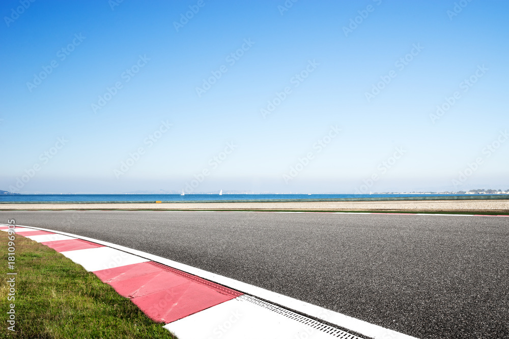 empty asphalt road with blue sea in blue sky