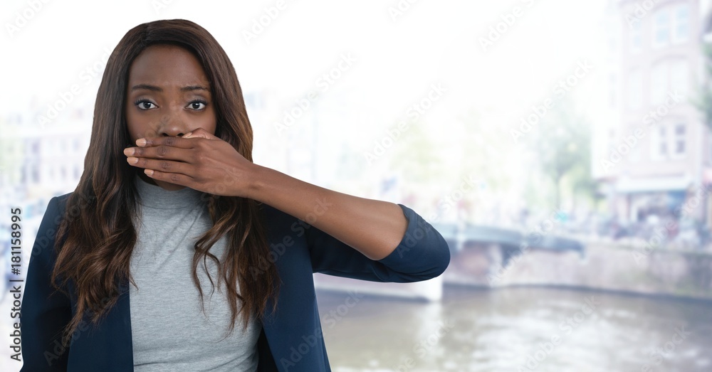 Businesswoman covering mouth with hand in city