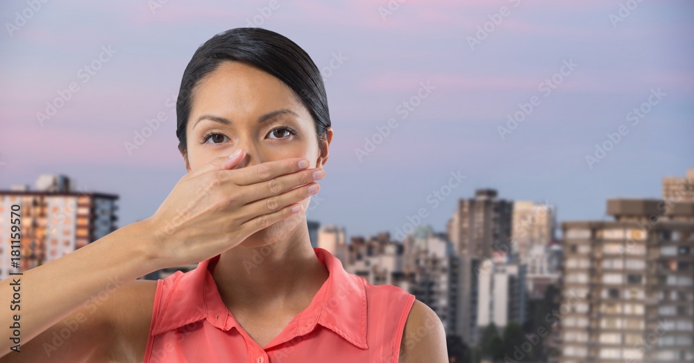 Businesswoman covering mouth with hand in city