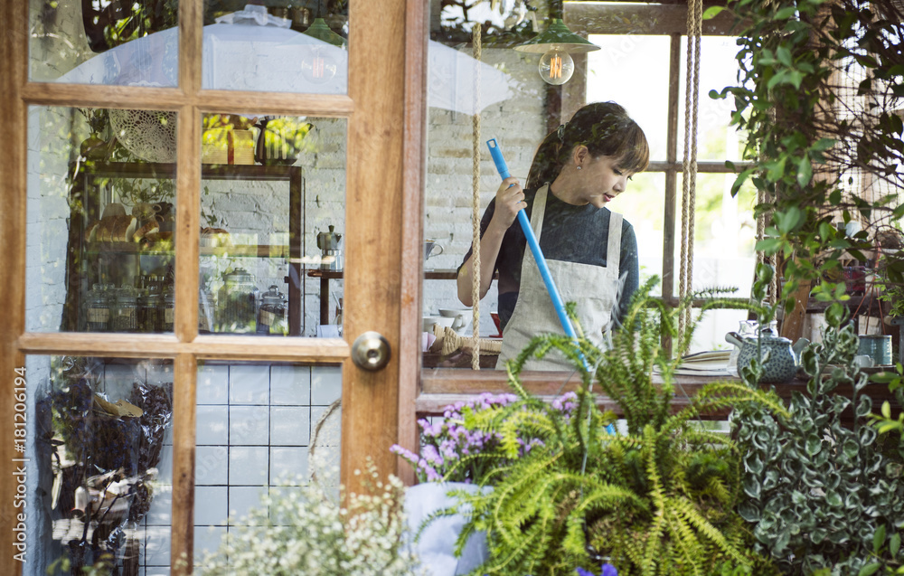 Woman cleaning up inside her flower shop