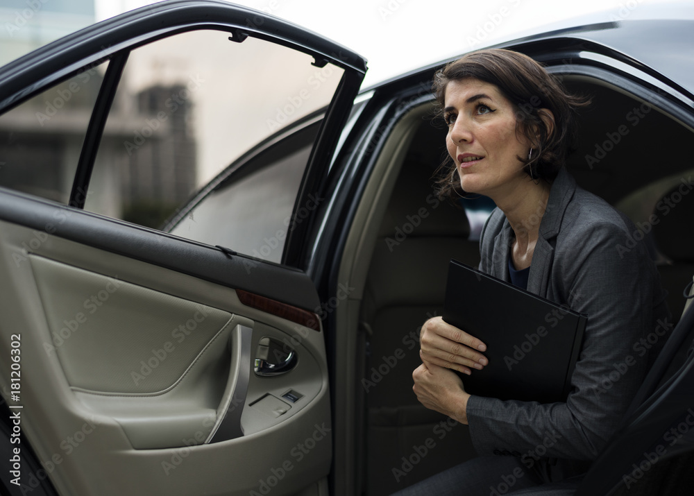 Businesswoman going out of his car