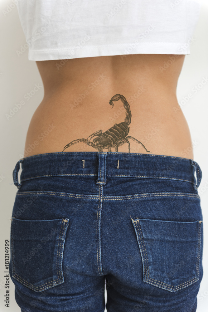 A woman is showing her tattoo on her hips