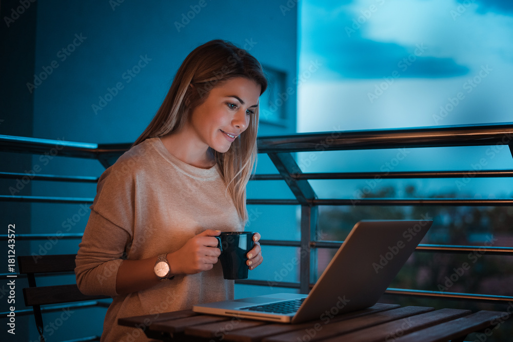 Young businesswoman working late on laptop. High ISO image.