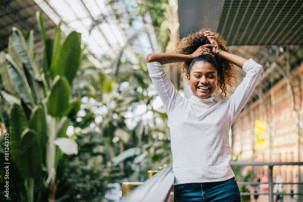 Young stylish woman holding her frizzy afro hair.