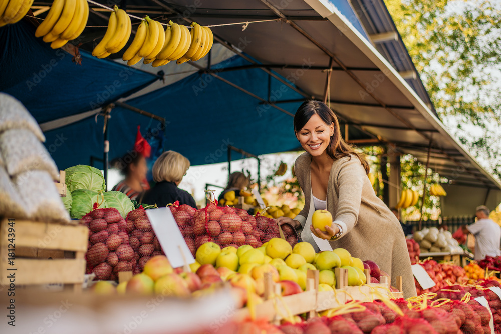 Woman looking for fruits at green market.