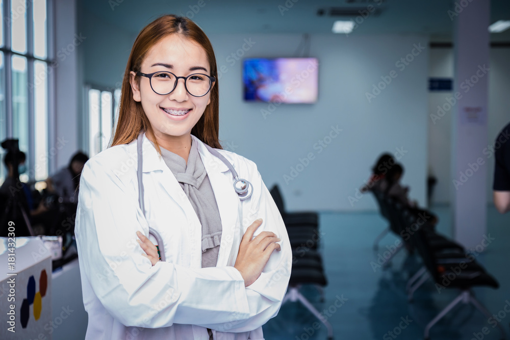 Young beautiful asian doctor woman smile face with stethoscope with waiting hall in hospital backgro