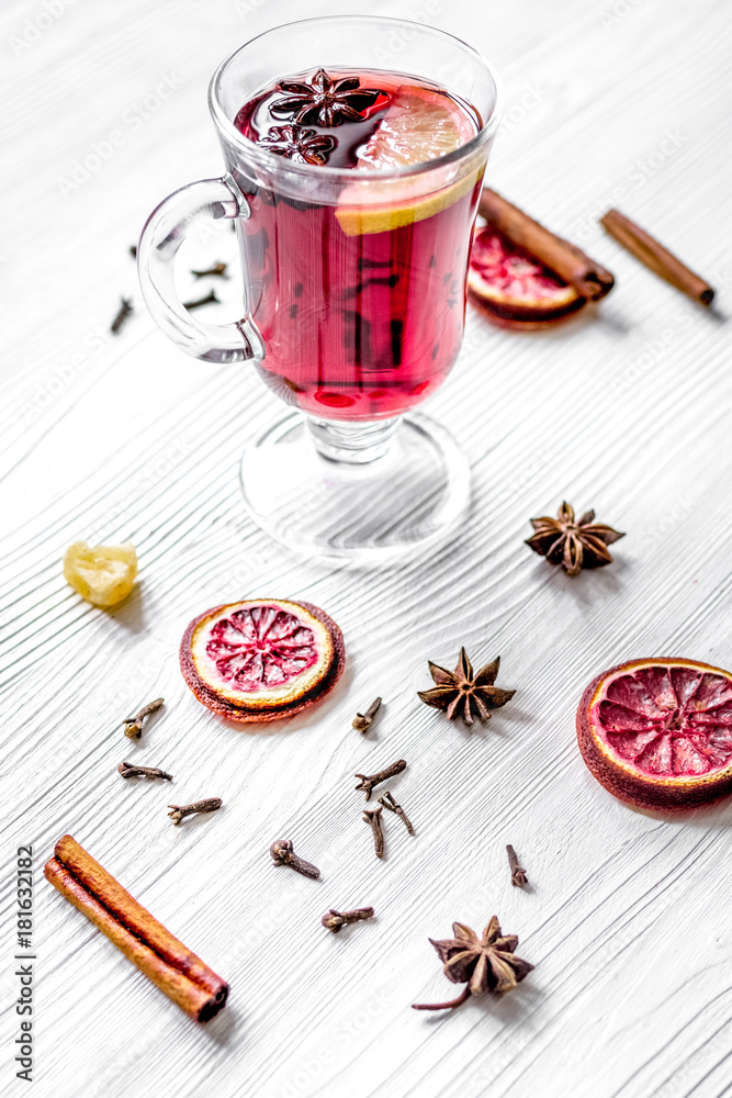 mulled wine with spices in cup on wooden background