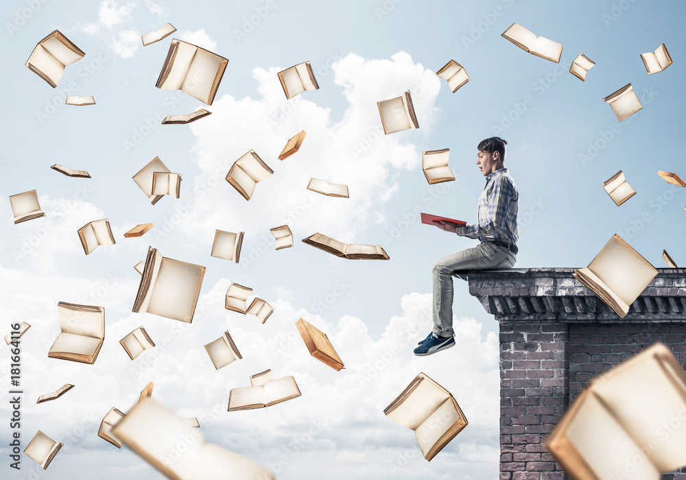 Man reading book and many of them flying in air