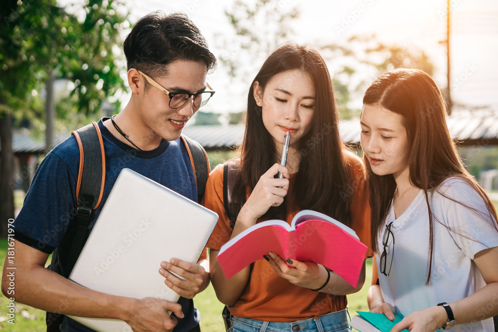 A group of young or teen asian student in university smiling and reading the book and look at the ta