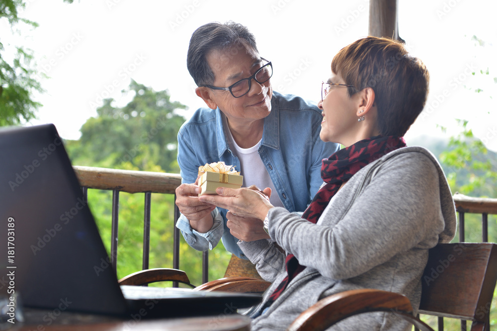 快乐的老人在家送礼物给妻子惊喜