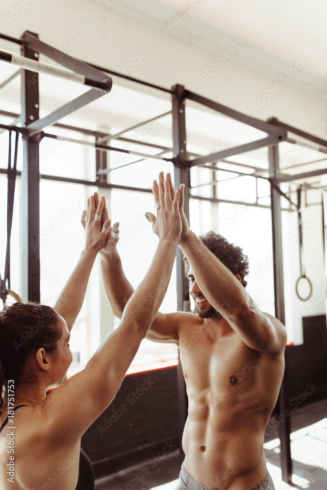 Fit couple high five after workout in health club