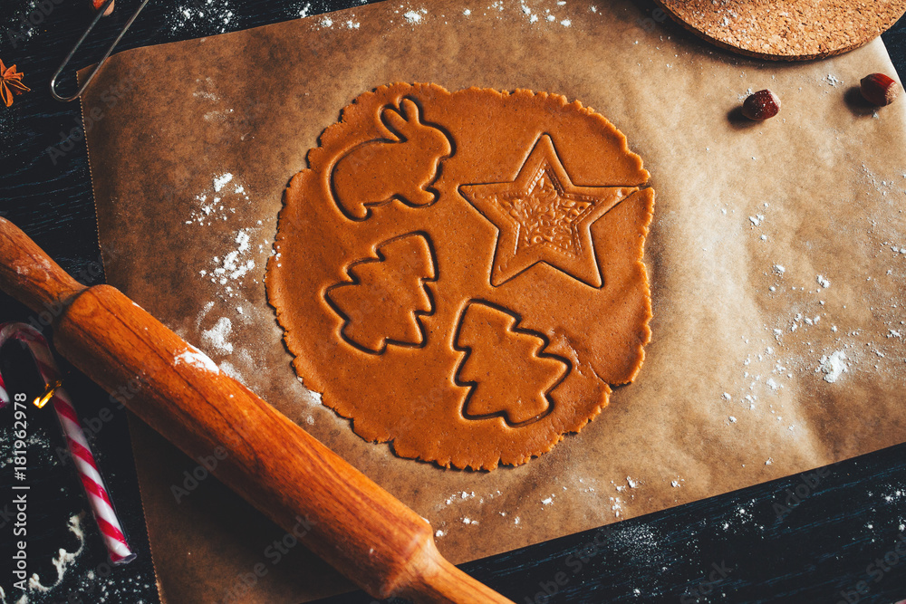 rolled dough with Christmas figures for biscuits on parchment paper