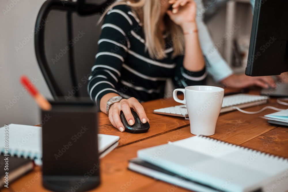 Businesswoman and colleague working at their desk in the office.