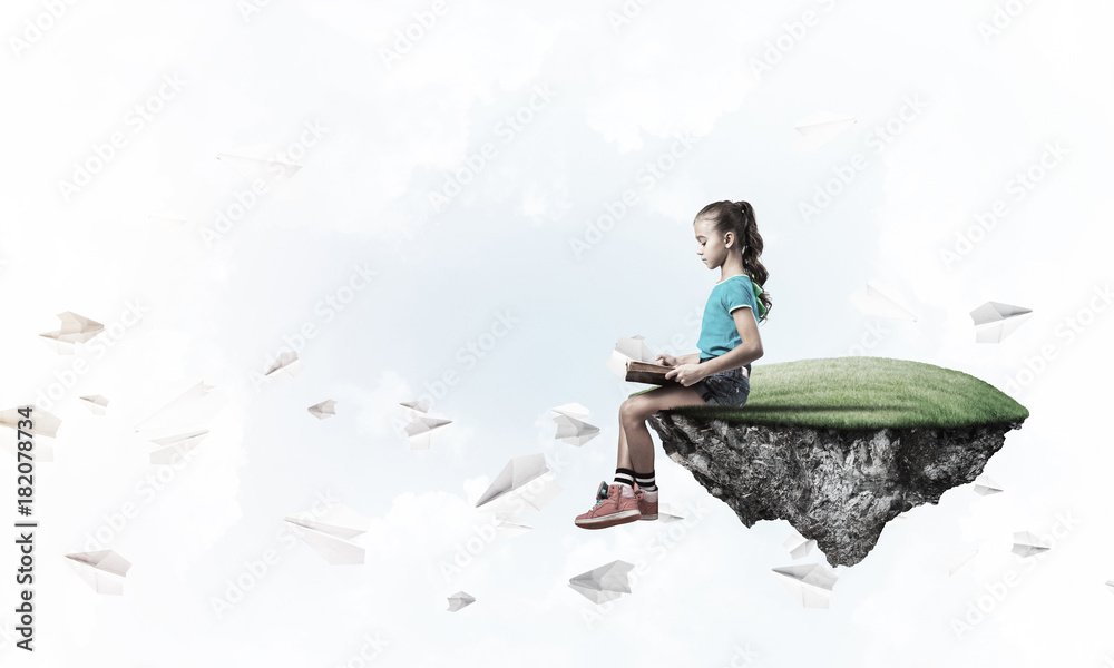 Concept of careless happy childhood with girl reading book