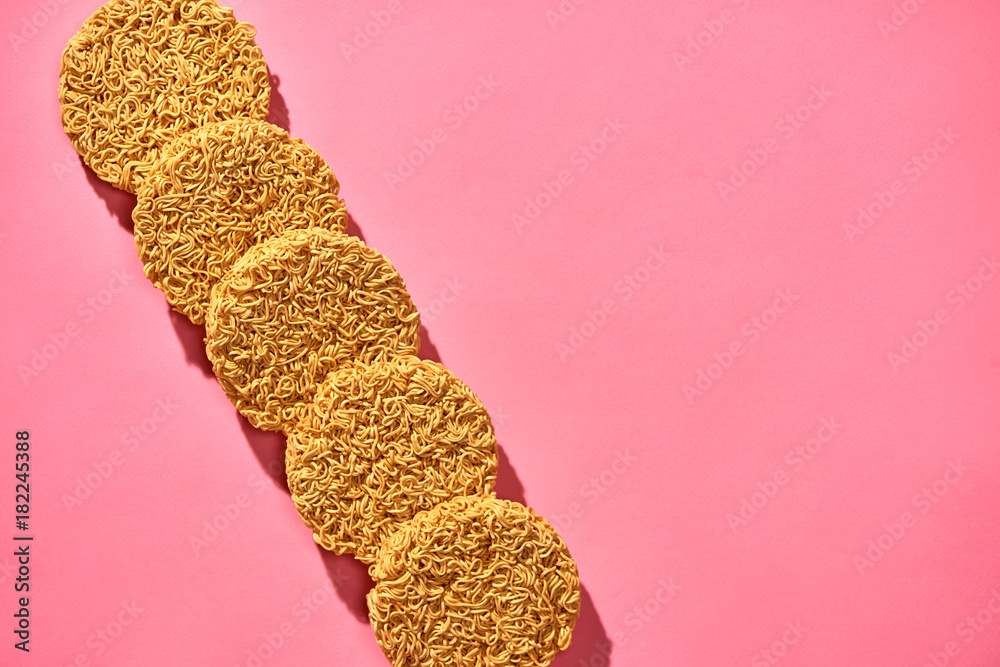 Dried instant noodles isolated on a pink background