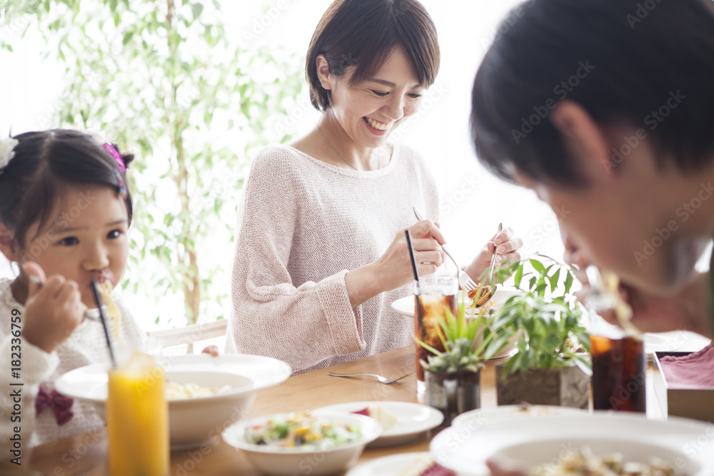 爸爸、妈妈和女儿正在吃意大利面。