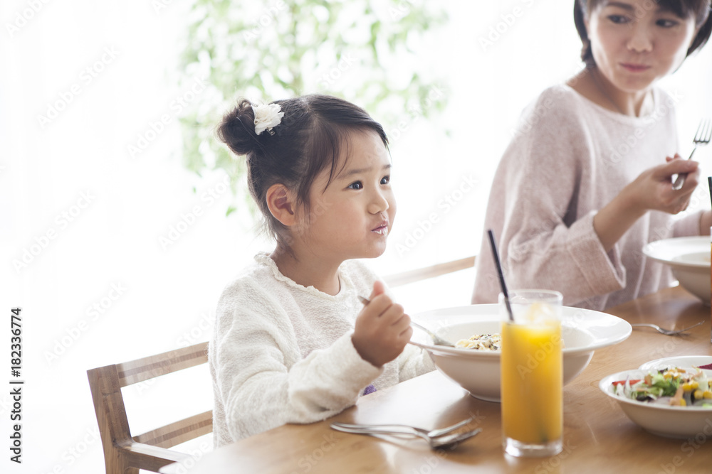 爸爸、妈妈和女儿正在吃意大利面。