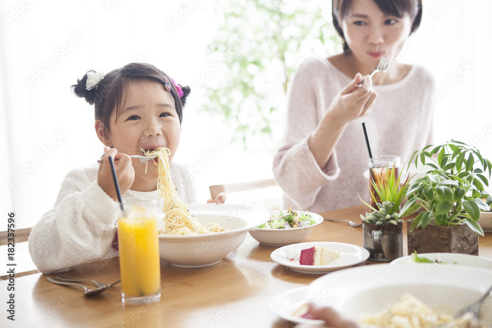 爸爸、妈妈和女儿正在吃意大利面。