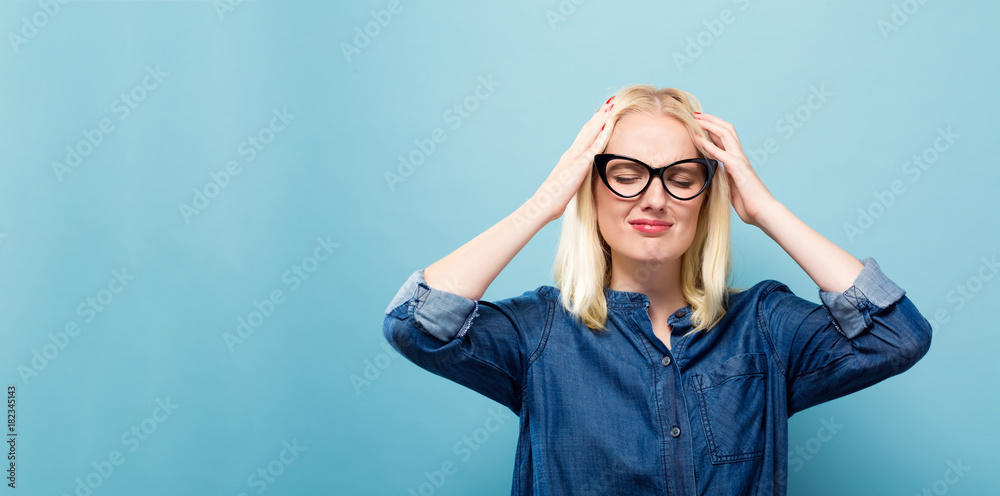 Young woman feeling stressed on a solid background