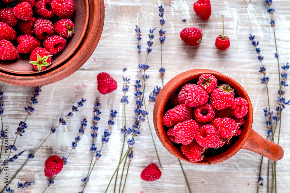 raspberry in pottery and lavender flowers on rustic background t