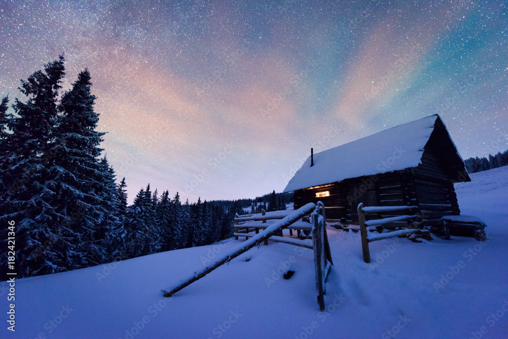 星光照耀下的奇妙冬季景观。白雪皑皑的木屋和